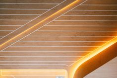 the interior of a building with wooden floors and ceilinging, illuminated by yellow lights