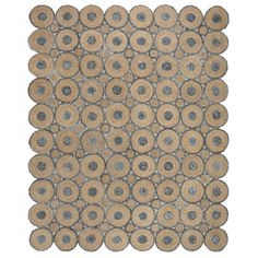 an area rug with circles and dots on the bottom, in grey and tan colors