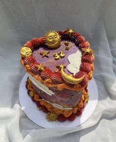 a decorated cake on top of a white plate with stars and moon decorations around it