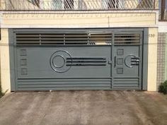 a garage with an iron gate and wooden flooring in front of a beige building