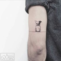 a small dog tattoo on the arm