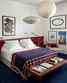 a bed room with a neatly made bed and pictures on the wall