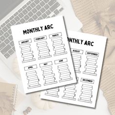 two printable planner pages sitting on top of a desk next to a laptop computer