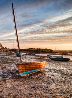 a boat sitting on top of a sandy beach