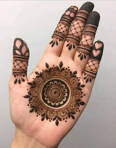 a hand with henna tattoos on it and two fingers in the shape of a circle