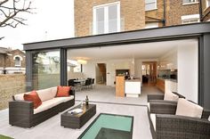 an outdoor living area with couches, tables and chairs