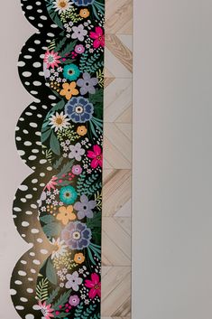 the back side of a skateboard with flowers and polka dots painted on it's sides