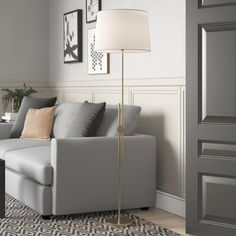 a living room scene with focus on the couch and floor lamp in the corner,