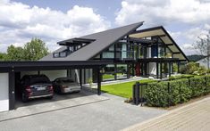 a car is parked in front of a house with a black roof and white trim