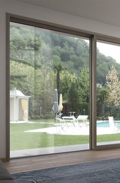 an open living room with sliding glass doors leading to a swimming pool and patio area