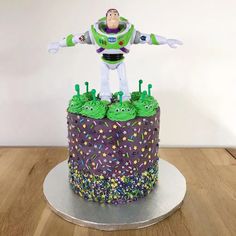 a toy story cake with buzz lightyear figure on top and sprinkles