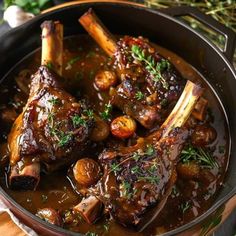 a pot filled with meat and vegetables on top of a wooden table