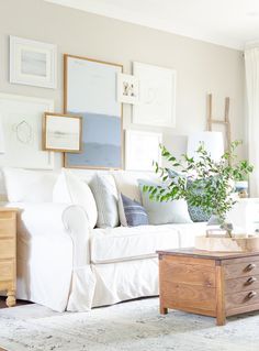 a living room filled with furniture and pictures on the wall