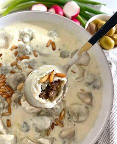 a spoon full of soup with meatballs and vegetables