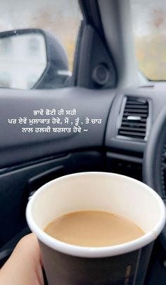 a cup of coffee sitting in the passenger seat of a car with a quote written on it