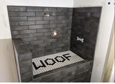 a tiled shower with the word woof written on it