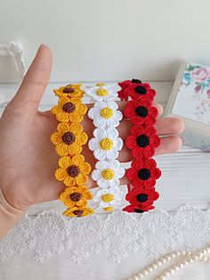 three crocheted bracelets with flowers on them