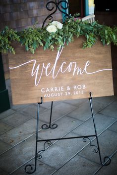 a welcome sign with greenery on it