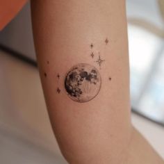 a woman's arm with a small tattoo of the moon and stars