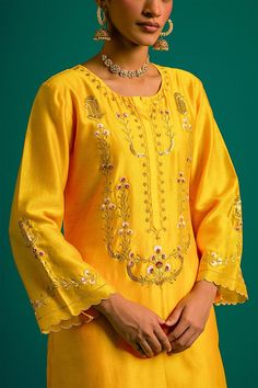 Yellow silk chanderi kurta with placed thread floral embroidery and scalloped edges. Comes with matching pant and contrast wine dupatta.
Components: 3
Pattern: Embroidered
Type Of Work: Floral,Sequin
Neckline: Round
Sleeve Type: Full
Fabric: Kurta and Pant: Silk Chanderi, Dupatta: Chanderi
Color: Yellow
Other Details: 
Model Height: 5ft 6inches wearing size S
Closure: Kurta: Front hook
Occasion: Mehendi and Haldi - Aza Fashions Floral Embroidered Palazzo Set With Straight Kurta For Diwali, Diwali Palazzo Set With Floral Embroidery And Straight Kurta, Art Silk Palazzo Set With Chikankari Embroidery, Embroidered Cotton Silk Palazzo Set For Eid, Festive Tussar Silk Palazzo Set With Cutdana, Festive Palazzo Set With Cutdana In Tussar Silk, Slub Silk Palazzo Set With Resham Embroidery, Embroidered Slub Silk Palazzo Set, Festive Embroidered Chanderi Palazzo Set