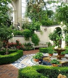 a garden with many plants and trees in the center, surrounded by brick walkways