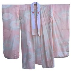 "This lovely vintage furisode nagajuban (underkimono) is made of a pale pink and cream rinzu silk with a woven pattern of stripes and peonies. It also features an attached cream silk decorative haneri collar with beautifully embroidered flowers in orange and peach. Furisode are the most formal style of kimono for unmarried women and are named after their long, swinging sleeves. Measurements: Length (from bottom of collar to hem): 48\" Width (cuff to cuff): 52\" Sleeve length (top to bottom): 44\