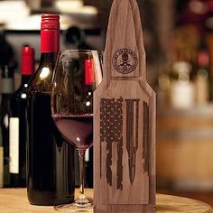 a wooden wine bottle holder sitting on top of a table next to a glass of wine