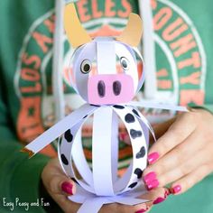 a person holding a paper cow in their hands