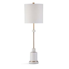 a white table lamp with a gold base and a white shade on the top, against a white background