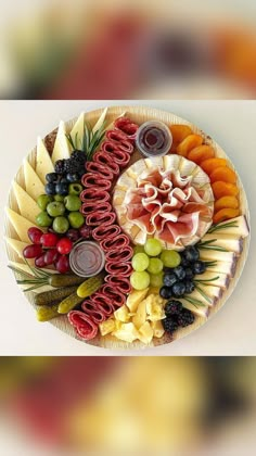 a platter filled with different types of cheeses, meats and fruit on top of each other