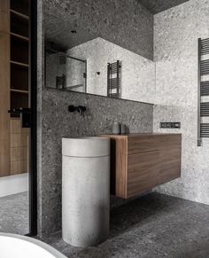 a bathroom with a sink, mirror and trash can in the middle of the room