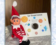 an elf is sitting next to a board with planets on it