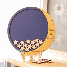 a wooden plaque with stars on it sitting on a table next to some gold coins