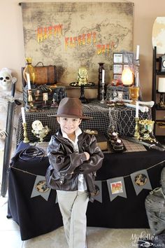 a young boy standing in front of a table with halloween decorations