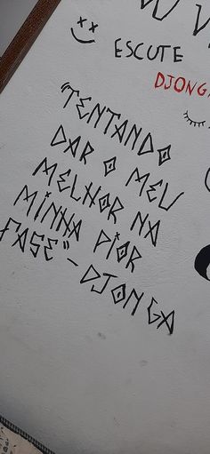 graffiti written on the side of a white wall with writing in different languages and numbers