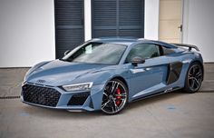 a blue sports car parked in front of some garage doors