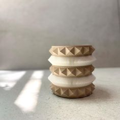 three white vases stacked on top of each other