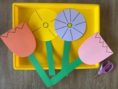 paper flowers and scissors on a yellow tray