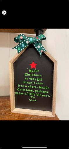 a chalkboard sign with a green polka dot bow hanging from it's side