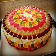 a cake with gummy bears on it sitting on top of a white platter