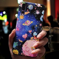 a person holding up a phone case with an image of space and stars on it