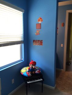 a small child's room with blue walls and a teddy bear on a chair