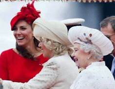 two women in red dresses and hats are smiling at each other as they stand next to one another