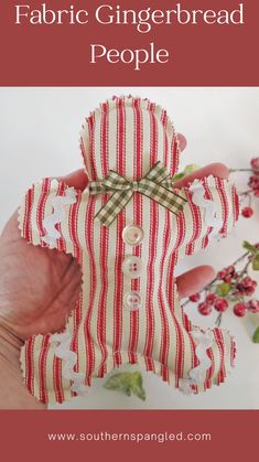 a hand holding up a red and white striped gingerbread teddy bear with the words fabric gingerbread people on it