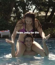 a man riding on the back of a woman in a swimming pool while she holds her