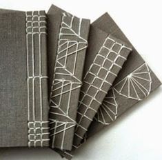 five gray notebooks with white lines on them