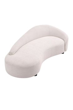 a white curved couch sitting on top of a white floor