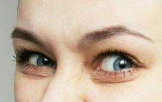 a close up of a woman's face with blue eyes