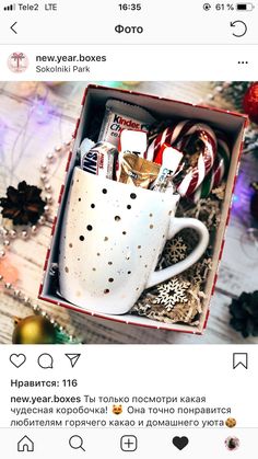 a cup filled with candy canes sitting in a box on top of a table