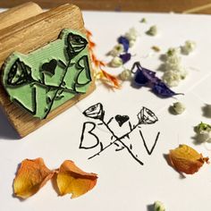 a rubber stamp with the word bxv on it next to some dried flowers